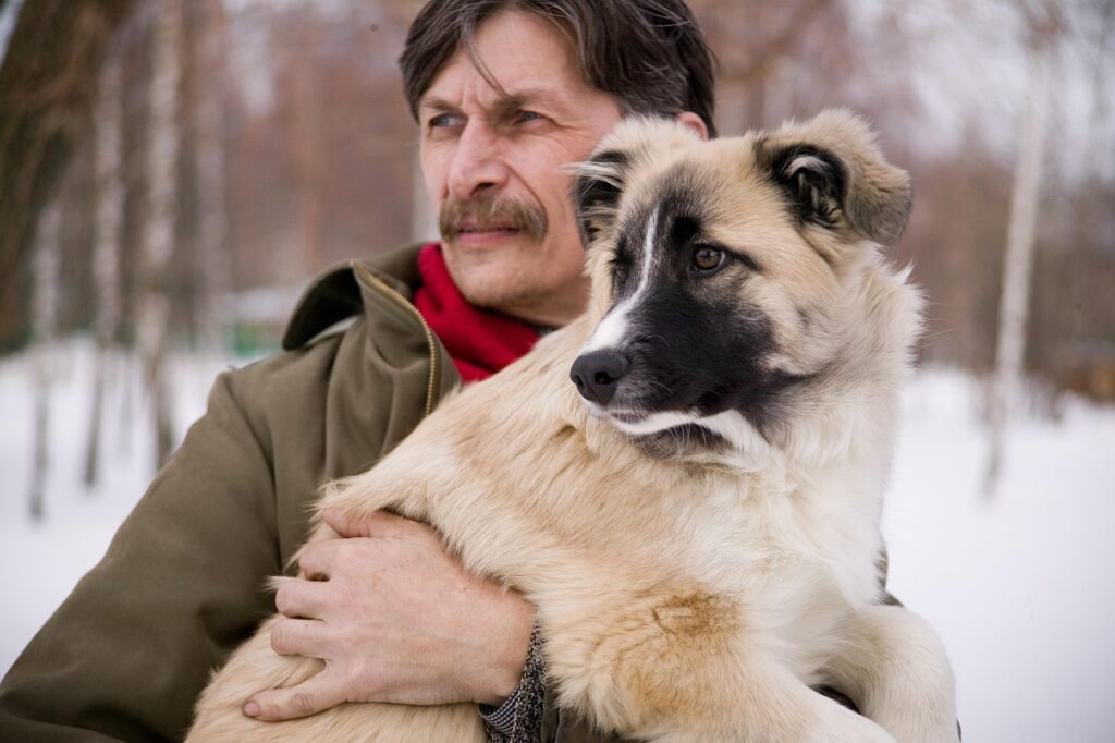 Mann hält Hund im Arm